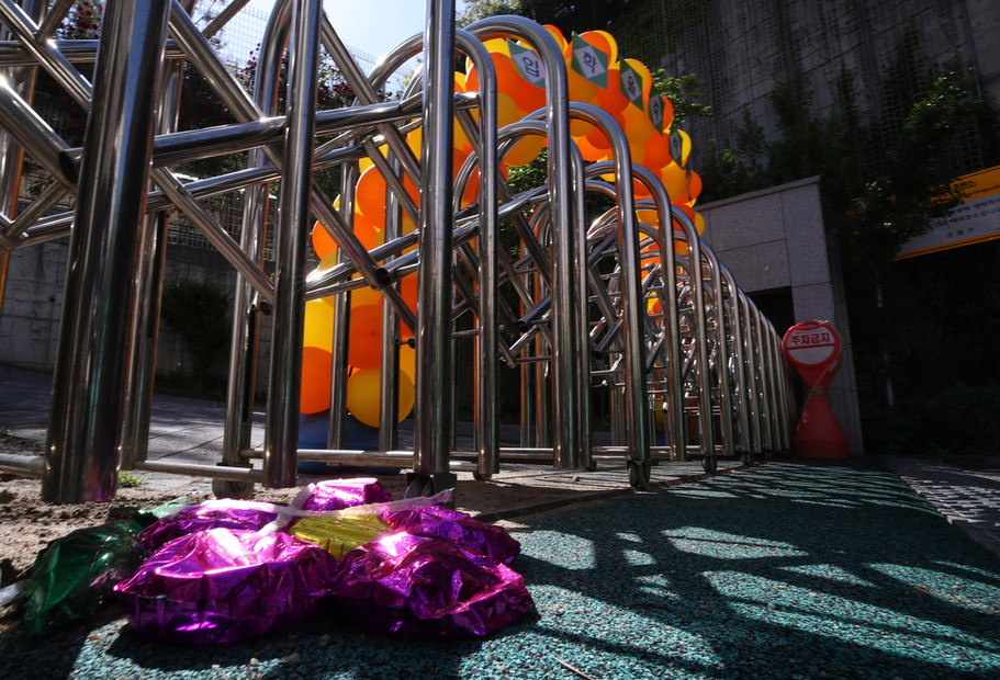 27일 전날 코로나19 확진자 발생으로 폐쇄된 서울 은평구 연은초등학교 입구에 전날 내린 비에 부착된 꽃 모양의 신입생 환영 장식물이 젖은 채 떨어져 있다. 연합뉴스