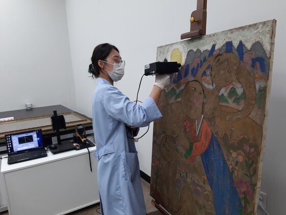 최영림 작가의 그림에 분광분석기를 대고 물감층 성분을 탐색하는 재료분석실 작업 모습.
