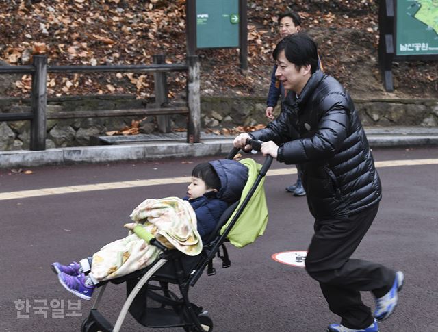 16일 남산 백범광장에서 열린 제481회 한국일보 거북이마라톤에 참가한 시민이 어린 아이를 태운 유모차를 밀며 남산길을 오르고 있다. 이한호 기자