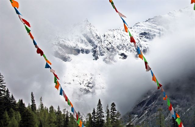 중국 쓰촨성 동티베트 쓰구냥산에서 본 포탈라봉. 타르초 뒤편으로 해발 5,000m급 봉우리가 만년설에 덮여 있다.