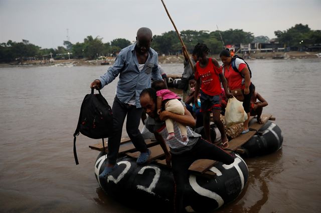 이민자들이 강을 건널 때 타는 뗏목의 예시. 사진은 과테말라와 멕시코의 국경지대를 지나는 수치아떼강을 건너는 아이티 출신 이민자들의 모습. 테쿤우만=로이터 연합뉴스