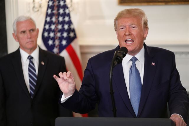 도널드 트럼프(오른쪽) 미국 대통령이 23일 미 워싱턴DC 백악관에서 시리아 사태에 관한 성명을 발표하고 있다. 트럼프 대통령은 "시리아 국경에서 큰 성공을 거뒀다"고 자찬하면서 터키에 대한 제재를 해제한다고 밝혔다. 워싱턴DC=로이터 연합뉴스