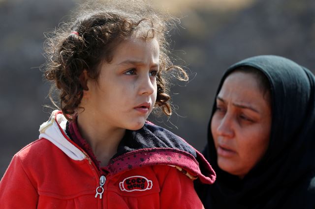 9일 시작된 터키의 시리아 북동부 지역 침공으로 난민 수십만명이 발생한 것으로 보고되는 가운데, 시리아와 이라크 국경 인근의 세말카 국경 검문소 주변에서 피난길에 오른 한 쿠르드계 소녀가 검문을 기다리고 있다. 세말카=로이터 연합뉴스