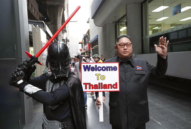 아세안(ASEAN·동남아시아국가연합) 정상회의 개막을 하루 앞둔 1일(현지시간) 태국  방콕에서 김정은 북한 국무위원장을 닮은 태국인 태국인 우텐 루앙상통씨와  영화 스타워즈의 다스 베이더 분장을 한 사람이 '태국에 오신 것을 환영한다'는 팻말을 들고 포즈를 취하고 있다. EPA 연합뉴스