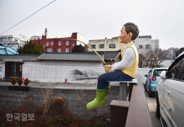 제민천을 가로지르는 다리 위에 낚시하는 모습을 형상화한 조각이 세워져 있다.