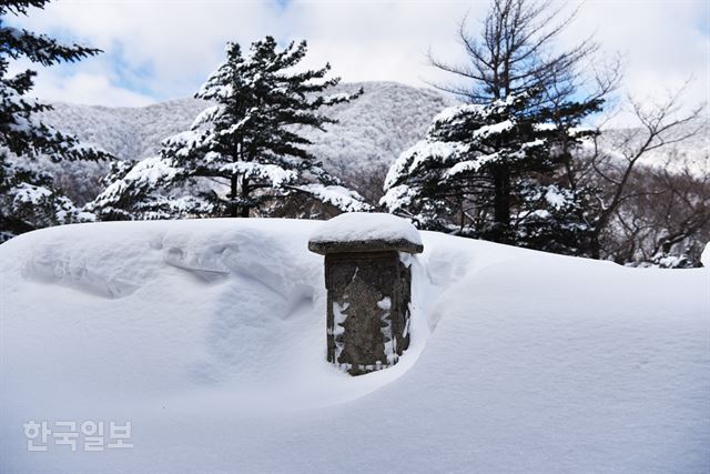 진신사리를 봉안한 무덤에도 소박한 비석 하나만 있다. 눈 덮인 비석 뒤로 오대산 정상인 비로봉이 보인다.