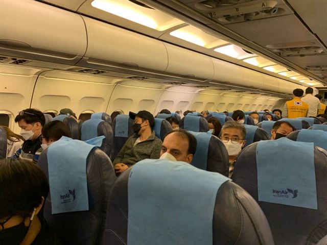 이란에 살고 있는 교민들이 18일 오후 10시(현지시간)쯤 테헤란 이맘호메이니 국제공항에서 이란항공에 탑승해 이륙을 기다리고 있는 동안 노란색 조끼를 입은 대사관 직원들이 승객들을 살피고 있다. 교민과 이란인 가족 84명은 이날 이란항공을 타고 UAE 두바이로 갔다 아시아나항공을 타고 귀국한다. 이란교민 제공