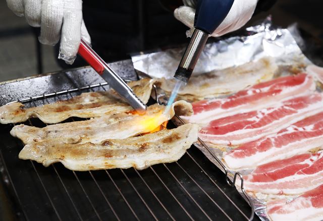 울산큰애기야시장의 명물 삼겹살김밥에 들어갈 삼겹살을 굽는 장면.