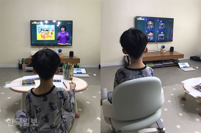 [저작권 한국일보]20일 서울 성북구 한 아파트에서 개학을 맞은 초등 1학년 A군이 EBS방송을 통해 원격수업을 받고 있다. 편한 차림에 핫도그를 먹으며 수업 받던 A군은 ‘바른 자세’ 교육이 나오자 의자를 가져와 정자세로 고쳐 앉았다. 독자 제공