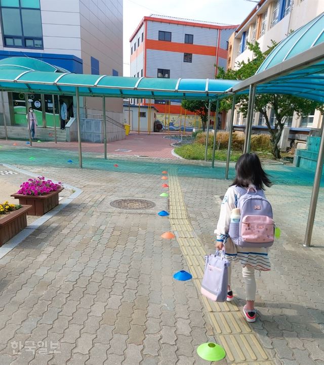 한 어린이가 27일 아침 대구 중구 한 초등학교에서 거리두기 표식을 따라 교실로 들어가고 있다. 김민규 기자 whitekmg@hankookilbo.com