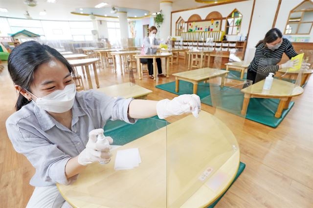 등교 수업 시작을 하루 앞둔 26일 오후 경기도 수원시 장안구 한일초등학교 병설 유치원에서 교사들이 신종 코로나바이러스 감염증(코로나19) 확산 방지를 위해 설치한 칸막이를 소독하고 있다. 수원=뉴스1