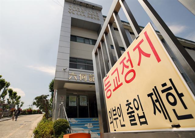 28일 서울 상일미디어고 교문에 붙은 '등교 정지' 안내판. 이 학교 3학년 학생이 확진판정을 받으면서 등교중지가 결정됐다. 연합뉴스