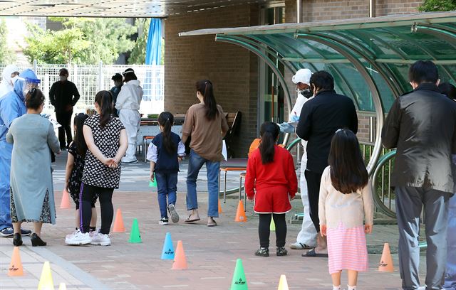 지난달 29일 교사 신종 코로나바이러스 감염증(코로나19) 확진자가 발생한 인천 서구 백석초등학교에 마련된 임시 선별진료소에서 학생과 학부모들이 검사를 기다리고 있다. 연합뉴스
