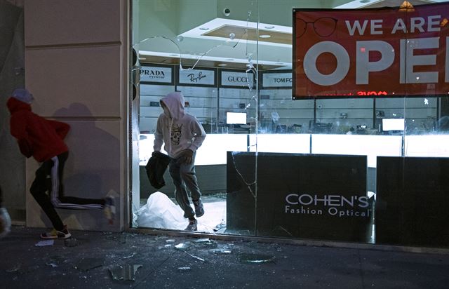 뉴욕의 첼시에서 1일 흑인 사망 항의 시위 중 일부 시민들이 한 보석가게에서 물건을 약탈해 나오고 있다. 뉴욕=AP 연합뉴스