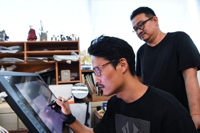 [저작권 한국일보] 최근 단행본이 출간된 웹툰 '지옥'의 연상호, 최규석 작가가 15일 오후 경기 부천시 한국만화영상진흥원에 있는 최 작가의 작업실에서 작업을 하고 있다. 이한호 기자