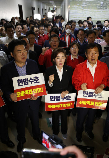 자유한국당 나경원 원내대표(가운데)가 30일 새벽 국회에서 정치개혁특별위원회가 열린 정무위원회 앞에서 구호를 외치고 있다. [연합]