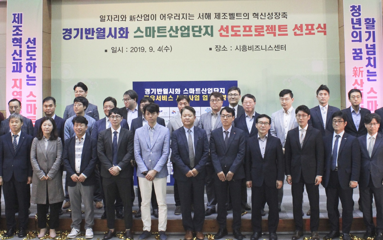 〈사진〉4일 경기 시흥 비즈니스센터에서 열린 스마트산단 비전 선포식에서 SK인포섹이 한국산업단지공단과 공유 서비스 업무 협약을 체결했다. 이수영 SK인포섹 DS사업 그룹장(맨 앞줄 오른쪽에서 다섯번째)이 관계자들과 함께 기념 사진을 찍고 있다. [SK인포섹 제공]