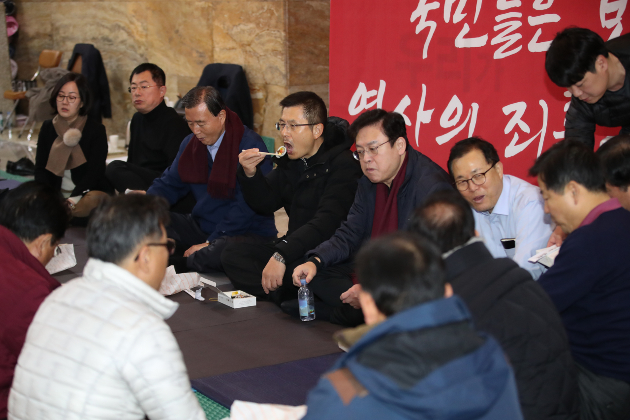 선거법과 검찰개혁법 등 패스트트랙(신속처리안건) 법안 저지를 위해 서울 여의도 국회 로텐더홀에서 밤샘 농성을 진행 중인 황교안 자유한국당 대표가 16일 오전 동료 의원들과 김밥 등으로 아침 식사를 하며 대책을 논의하고 있다. [연합]