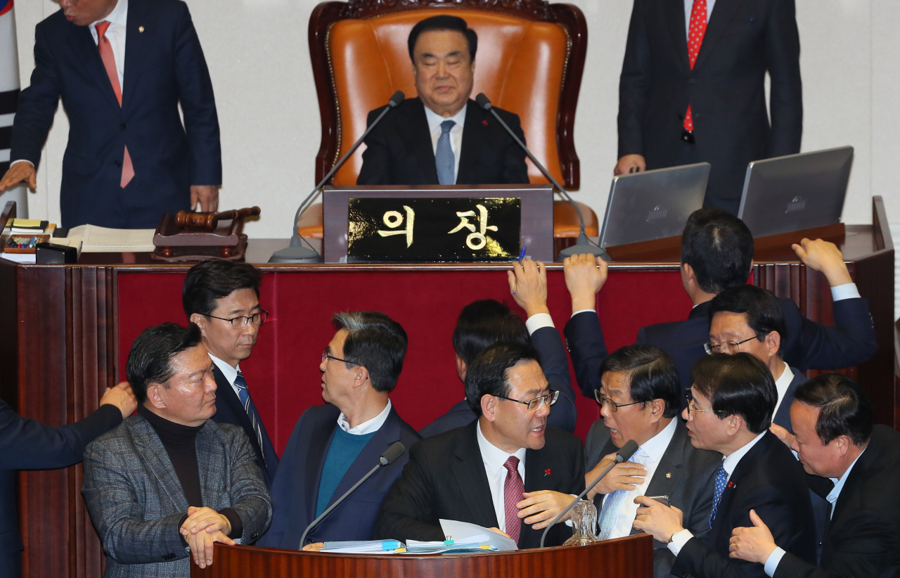 23일 국회 본회의에서 '임시국회 회기안건'에 '무제한 토론'을 신청한 자유한국당 주호영 의원(가운데)이 문희상 의장에게 거절 당한 뒤 다음 토론 차례인 더불어민주당 윤후덕 의원(오른쪽 세번째)과 단상을 두고 싸우고 있다. [연합]
