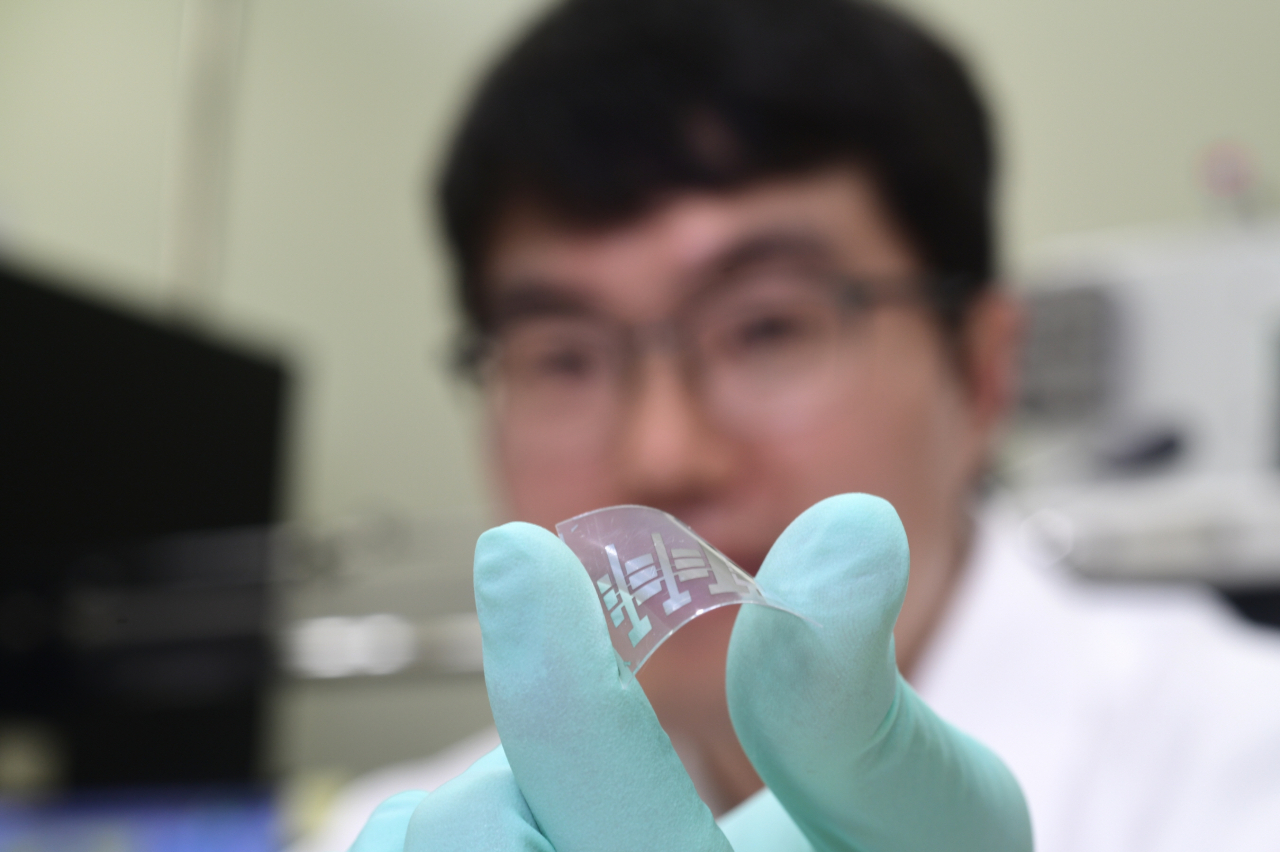 임경근 박사가 수직으로 쌓은 고성능 유기 트랜지스터를 들어보이고 있다.[한국표준과학연구원 제공]