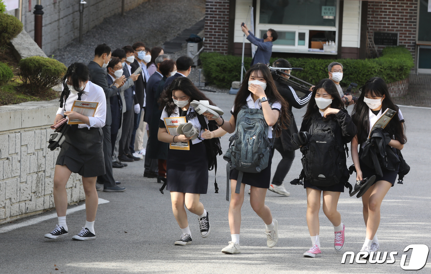 고등학교 3학년 등교 개학이 시작된 지난 20일 오전 충북 청주시 상당구 금천고등학교에서 학생들이 교사들의 환영인사를 받으며 등교하고 있다. 2020.5.29/뉴스1 © News1 김용빈 기자