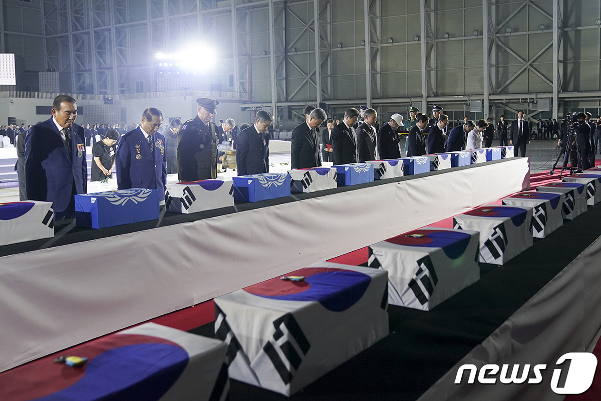 문재인 대통령이 25일 경기 성남 서울공항에서 열린 6.25전쟁 70주년 행사에서 국군 전사자들의 유해함에 참전기장을 수여한뒤 참석자들과 묵념하고 있다.(청와대 제공)2020.6.26/뉴스1