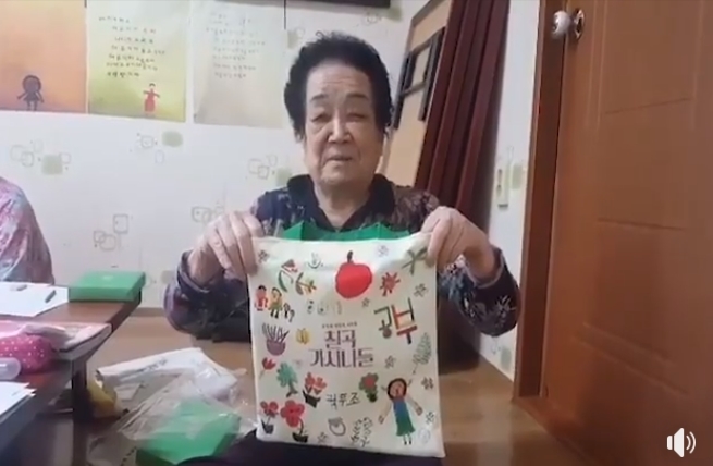 김정숙 여사가 보낸 책주머니를 들고 영상편지를 촬영하고 있는 곽두조 할머니.[사진=청와대 페이스북 캡처]