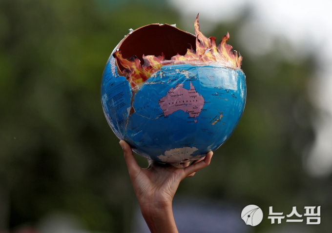 [뭄바이 로이터=뉴스핌] 민지현 기자 = 전 세계 주요 도싱서 연쇄 기후파업이 진행되는 가운데 27일(현지시간) 인도 뭄바이에서 벌어진 기후변화 시위에서 한 참가자가 불에 타고있는 지구 모형을 들고있다. 2019.09.27.