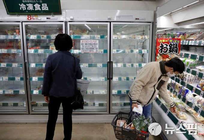 [도쿄 로이터=뉴스핌] 김은빈 기자 = 일본 도쿄에 위치한 한 슈퍼마켓에서 마스크를 쓴 시민들이 장을 보고있다. 슈퍼마켓의 냉동식품 진열대가 텅 비어있다. 2020.03.27 kebjun@newspim.com