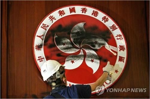 입법회 홍콩 상징물에 검은 물감 뿌리는 시위대(AFP=연합뉴스)