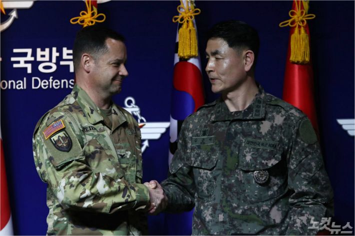 합참 공보실장 김준락 대령(오른쪽)이 27일 오전 서울 용산구 국방부에서 코로나19 확산으로 인한 한미연합군사훈련 연기에 대한 브리핑을 마치고 한미연합사 공보실장 피터스 대령과 악수를 하고 있다.(사진=이한형 기자)