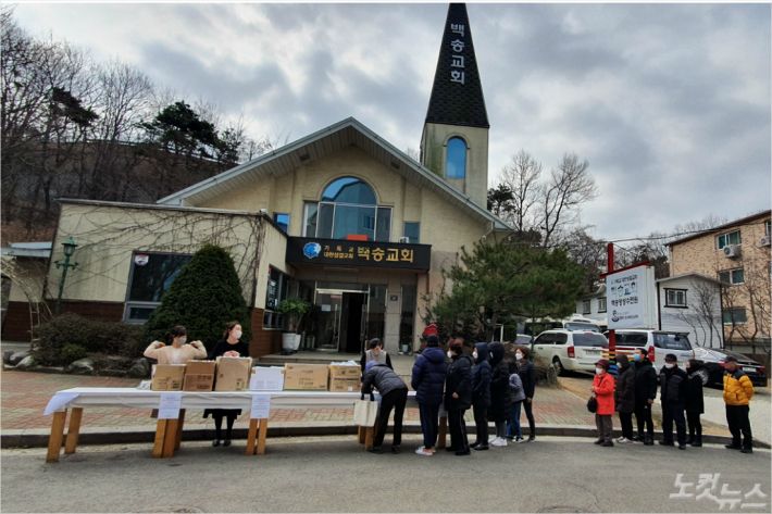백송교회에서 나눠주는 마스크를 받기 위해 주민들이 줄을 서고 있다.