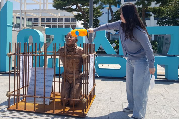 한 시민이 광주시 동구 5·18민주광장에서 '무릎 꿇은 전두환 동상'을 때리고 있다(사진=김한영 기자)