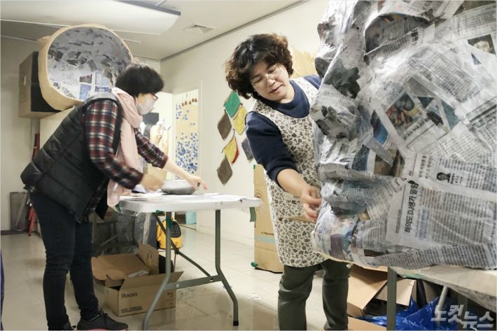 5월 유족들이 신문을 이용해 인형탈을 만들고 있다(사진=5·18민중항쟁기념행사위원회 제공)
