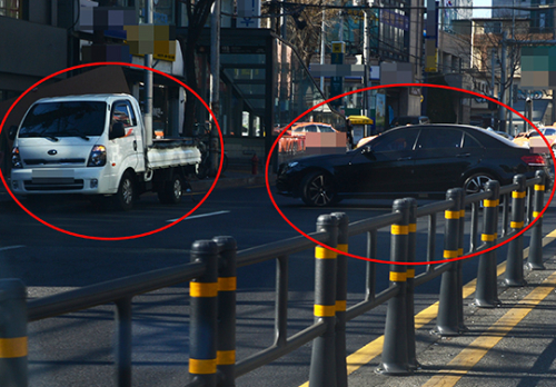 지하철 출입구 인근 차도에는 불법 주정차 된 차량이 차량 흐름을 방해하고 있다.