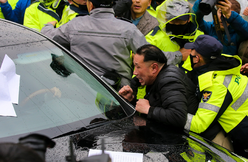 전두환 전 대통령이 5·18 민주화운동 관련 형사재판 출석을 마치고 광주지방법원을 빠져나가자 사죄를 촉구하는 시민이 차량을 막으며 항의하고 있다.