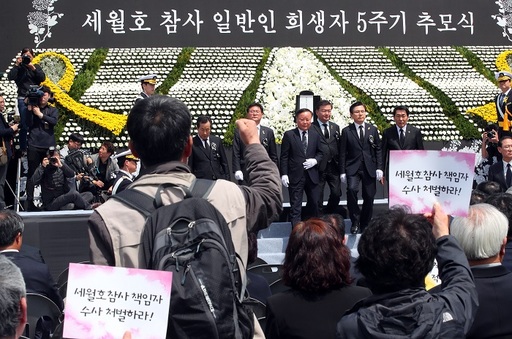 황교안 자유한국당 대표(오른쪽에서 두번째)와 당 관계자들이 16일 오전 인천 부평구 인천가족공원 내 세월호 일반인 희생자 추모관 앞에서 열린 5주기 추모식에서 헌화와 분향을 마치고 무대에서 내려오자 인천시민사회단체 회원들이 항의 구호를 외치고 있다. 연합뉴스