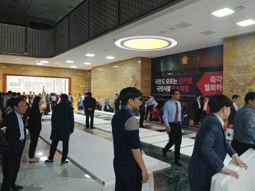 자유한국당 당직자들이 23일 국회 로텐더홀에 대형 스티로폼 깔개를 바닥에 깔고 있다.