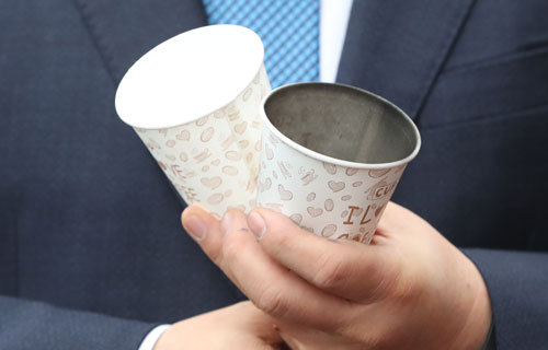 홍남기 부총리 겸 기획재정부 장관이 매연을 측정한 종이컵 2개를 들고 있다. 왼쪽이 미세먼지 저감 기능이 있는 신형 엔진의 매연을 측정한 종이컵이며 오른쪽이 기존 구형 엔진의 매연을 측정한 종이컵.