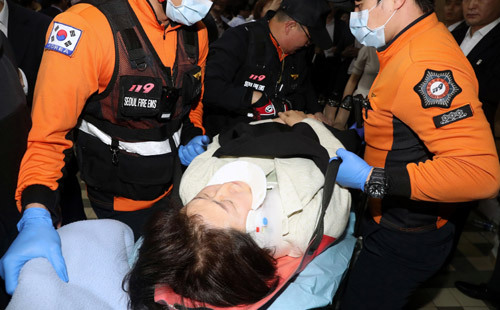 실려가는 여성 의원 패스트트랙 지정을 둘러싼 여야의 극한 대치가 이어진 26일 새벽 서울 여의도 국회 본청 의안과 앞에서 몸싸움 도중 쓰러진 자유한국당 김승희 의원이 119대원들에 의해 실려 나가고 있다. 뉴시스