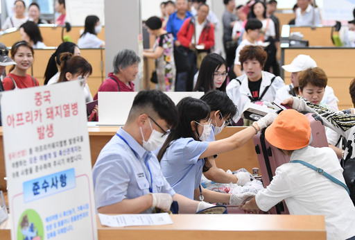 아프리카 돼지열병(ASF)이 한반도에 유입되면서 국내 양돈 농가에 대한 방역이 강화되는 등 방역과 검역 당국에 초비상이 걸린 가운데 지난 3일 경기 평택항 국제여객터미널 입국장에서 농림축산검역본부 직원들이 중국발 여객선 승객들을 대상으로 농축산물반입을 검역하고 있다. 평택=뉴시스