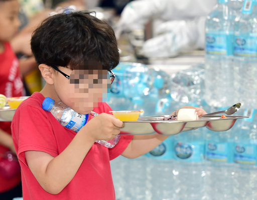 '붉은 수돗물'로 인천 서구·영종도·강화도 지역 학교 급식에 차질이 빚어진 17일 오전 인천시 서구 한 초등학교 급식실에서 한 학생이 배식받은 음식과 함께 생수병을 지급받고 있다.
