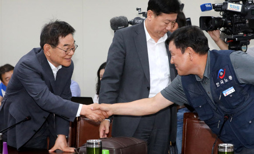 11일 오후 정부세종청사에서 열린 최저임금위원회 전원회의에서 박복규 사용자 위원과 이성경 근로자 위원이 악수하고 있다. 뉴시스