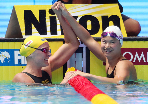 스웨덴의 사라 셰스트룀(왼쪽)이 지난 22일 남부대 시립국제수영장에서 열린 2019 광주세계수영선수권대회 경영 여자 접영 100m 결승에서 자신의 대회 4연패를 저지하고 우승한 캐나다의 마거릿 맥닐의 손을 들어올리며 축하하고 있다. 광주=연합뉴스