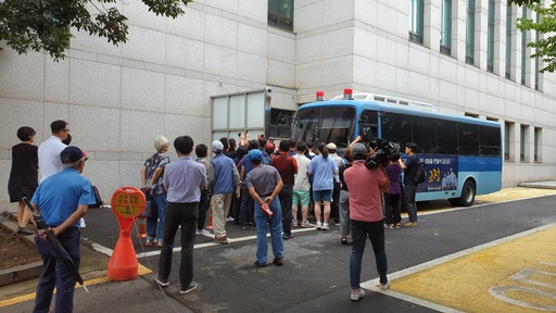 전 남편 살해 혐의로 구속기소 된 고유정이 12일 오전 제주지법에서 첫 재판을 받고 나와 호송차에 오르기 전 시민과 취재진이 몰려들고 있다. 제주=임성준 기자