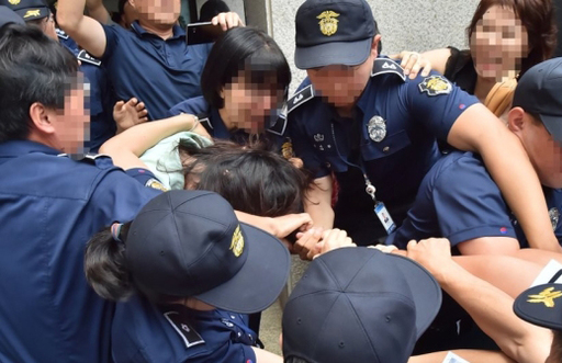 전 남편 살해 혐의로 구속기소 된 고유정이 지난 12일 오전 제주지법에서 첫 재판을 받고 나와 호송차에 오르기 전 한 시민에게 머리채를 잡히고 있다. 연합뉴스