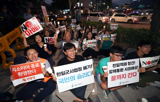 22일 서울 종로구 일본대사관 앞에서 서울겨레하나가 주최해 열린 시민 촛불 집회에서 참가자들이 한일군사정보보호협정(지소미아) 파기에 환호하고 있다. 뉴시스