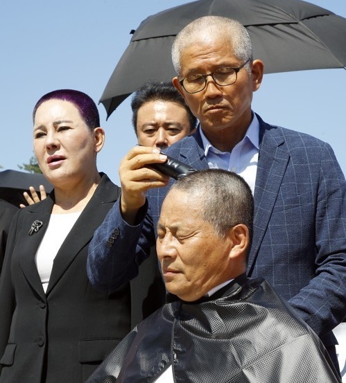 지난 18일 청와대 앞 분수대 광장에서 차명진 전 의원이 자유한국당 삭발 릴레이에 동참했다. 전날 삭발한 김문수 전 경기도지사가 직접 차 전 의원의 머리카락을 잘라주고 있다. 연합뉴스