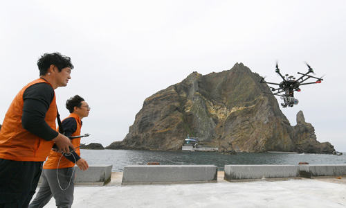 지난 23일 독도에서 국립문화재연구소 직원들이 라이다를 장착한 드론을 띄워 보고 있다. 국립문화재연구소 제공