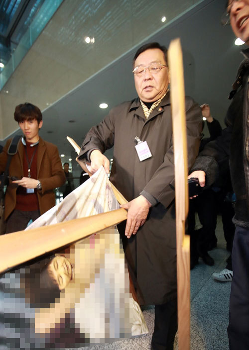 지난 2017년 1월 24일 한 보수단체 회원이 국회 의원회관 로비에서 열린 시국비판 전시회 ‘곧, 바이! 전(展)’의 작품 중 박근혜 대통령을 나체 상태로 풍자한 그림을 강제로 철거하고 있다. 연합뉴스